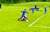 MK United U8 players in action as a player evades a sliding tackle just outside the box.